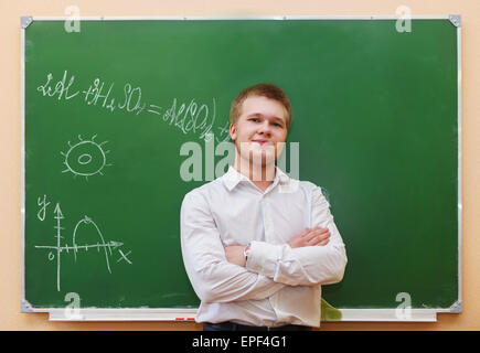 Debout près de l'élève le tableau noir dans la salle de classe Banque D'Images