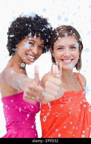 Portrait of teenage girls, fiers de présenter leurs Thumbs up against a white background Banque D'Images