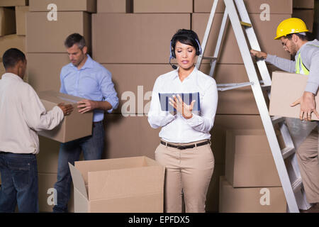 Jolie warehouse manager using tablet au cours de période de pointe Banque D'Images