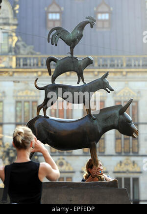 Une femme prend une photo d'une statue en bronze représentant "Les Musiciens de Brême" à Brême, Allemagne, 23 avril 2015. Photo : Ingo Wagner/dpa Banque D'Images