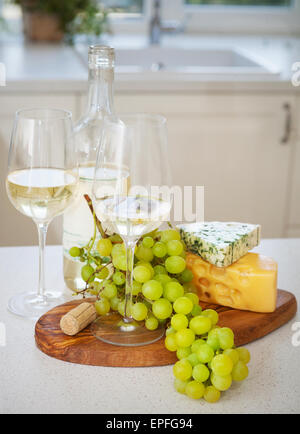 Diverses sortes de fromage, raisins et deux verres de vin blanc Banque D'Images