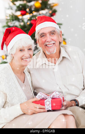 Smiling old couple échangeant des cadeaux de Noël Banque D'Images