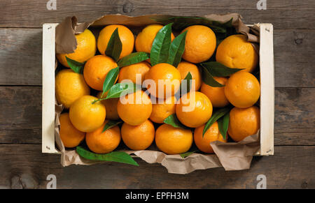 Fruits orange dans une boîte en bois sur une surface en bois. Banque D'Images
