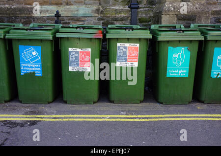 Une rangée de bacs de recyclage vert sur le côté d'une route à double lignes jaunes dans Britsol. Banque D'Images