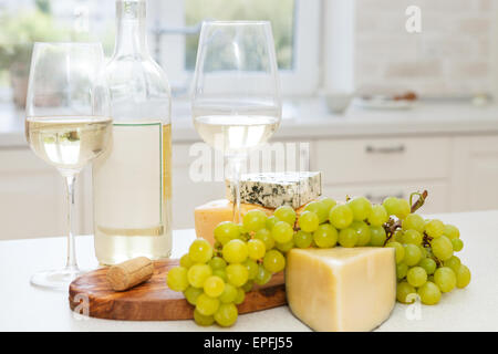 Diverses sortes de fromage, raisins et deux verres de vin blanc Banque D'Images