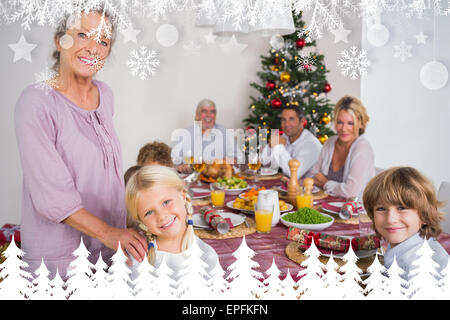 Image composite de grand-mère et sa petite-fille debout à côté de la table de dîner Banque D'Images