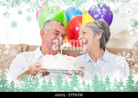 Senior couple sitting on couch fêter un anniversaire Banque D'Images