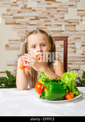 Petite fille avec des légumes à la lumière prix Banque D'Images