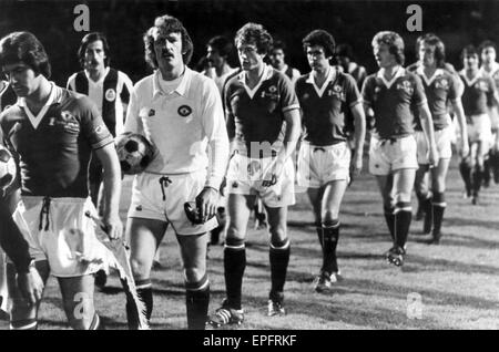 Porto v Manchester United, coupe d'Europe des vainqueurs de coupe 1ère manche match à l'Est‡dio Drag'o, Porto, Portugal, 19 octobre 1977. Martin Buchan, Manchester United Capitaine avec Fanion Club mène ses joueurs sur le terrain, suivi par Alex Stepney, Stewart Hous Banque D'Images