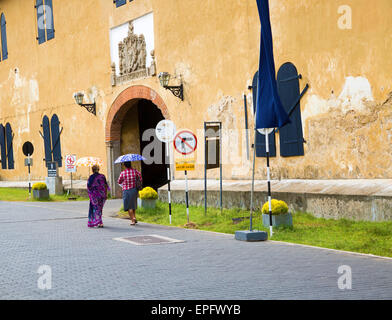 Femmes marchant avec parasols pour l'ombre vers le fort de la porte de sortie dans la ville historique de Galle, au Sri Lanka, en Asie Banque D'Images