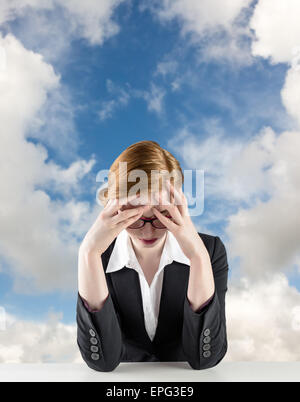 Image composite de redhead businesswoman with head in hands Banque D'Images