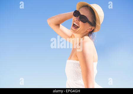 Jolie blonde en robe blanche et chapeau sur la plage Banque D'Images