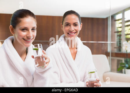 Smiling women in peignoirs l'eau potable Banque D'Images