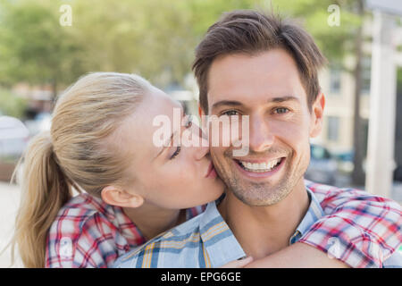 Jeune femme de la hanche copain baiser sur la joue Banque D'Images