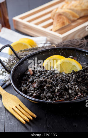 Risotto aux fruits de mer avec de l'encre de calmar sur pot noir Banque D'Images