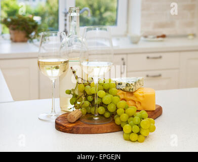 Diverses sortes de fromage, raisins et deux verres de vin blanc Banque D'Images