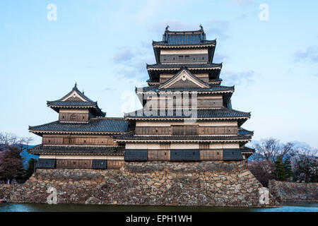 La destination touristique populaire, le château de Matsumoto au Japon. Le Keep, de style sotogata, avec le douve en premier plan pendant l'heure bleue du soir. Banque D'Images