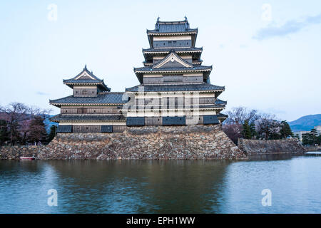 La destination touristique populaire, le château de Matsumoto au Japon. Le Keep, de style sotogata, avec le douve en premier plan pendant l'heure bleue du soir. Banque D'Images