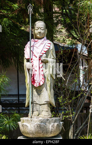 Jizo boddhisatva, bosatsu, statue avec orbe et personnel, shakujo, debout sur une base de pierre de lotus en plein soleil à un temple, Koyasan, Japon Banque D'Images