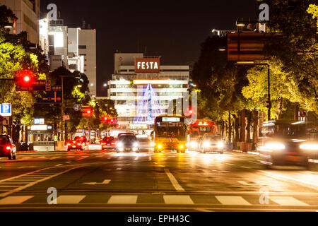 Vue de nuit le long de la rue Otemaedori avec circulation en attente au carrefour et passage piéton en premier plan, et le bâtiment Festa derrière. Banque D'Images