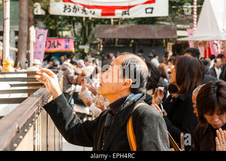 Nouvelle année au Japon. Homme jetant de la monnaie dans la grande boîte de collecte devant le hall principal du sanctuaire Yasaka à Kyoto pendant sa visite à Hatsumode. Banque D'Images
