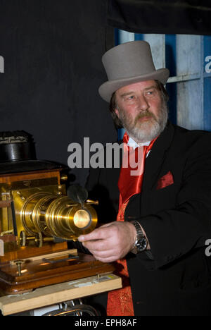 Habillés en costume victorien projectionniste pour un spectacle de lanterne magique, Hindhead, Hampshire, Royaume-Uni. Banque D'Images