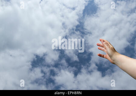 Mains et bras pour atteindre les cieux avec ciel bleu et nuages. Banque D'Images