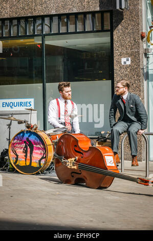 Quartier commerçant animé de Briggate, Leeds West Yorkshire,Deux jeunes musiciens de rue en faisant une pause, Banque D'Images