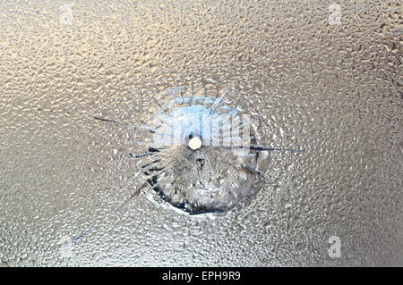 Bullet Aperture dans le verre humide, le verre brisé. Photo conceptuelle - danger Banque D'Images