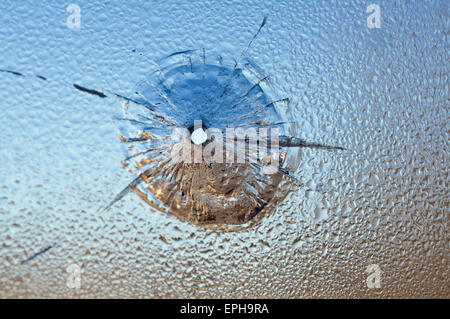 Bullet Aperture dans le verre humide, le verre brisé. Photo conceptuelle - danger Banque D'Images