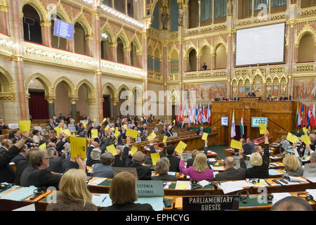 Budapest. 18 mai, 2015. Les législateurs de l'Assemblée parlementaire de l'OTAN par vote à l'aide des feuilles de couleur au cours de la séance plénière de la session de printemps de l'Assemblée parlementaire de l'OTAN à Budapest, Hongrie le 18 mai 2015. La Session de printemps de l'Assemblée parlementaire de l'OTAN qui a eu lieu ici a publié une déclaration commune lundi soulignant l'importance de l'élargissement et de recommander qu'avant la fin de l'année l'Alliance inviter le Monténégro à rejoindre. Credit : Attila Volgyi/Xinhua/Alamy Live News Banque D'Images