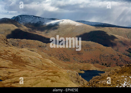 Easedale Tarn avec les sommets enneigés et Fairfield sandale de siège dans l'arrière-plan Grasmere Cumbria Lake District Banque D'Images