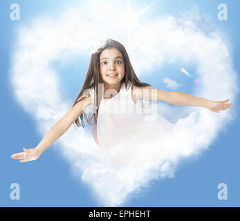 Petite femme voler dans un nuage heartshaped Banque D'Images