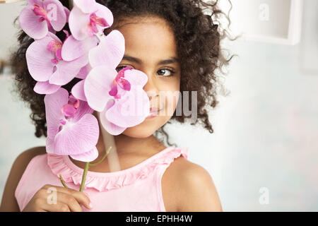 Petite fille joyeuse tenant une belle fleur Banque D'Images