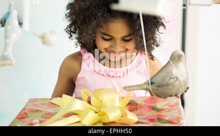 Adorable jeune fille d'ouvrir le cadeau d'anniversaire Banque D'Images