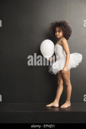 Image conceptuelle d'une petite danseuse de ballet avec un ballon blanc Banque D'Images