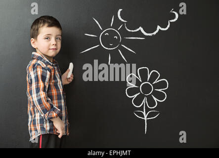 Petit garçon dessin sur le tableau noir Banque D'Images