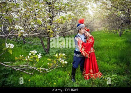 Couple en costume Kazakh au printemps fleurs jardin apple d'Almaty, Kazakhstan, en Asie centrale Banque D'Images