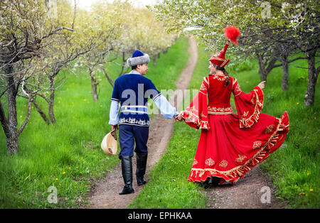 Couple en costume Kazakh marche autour de Spring Garden apple en fleurs d'Almaty, Kazakhstan, en Asie centrale Banque D'Images