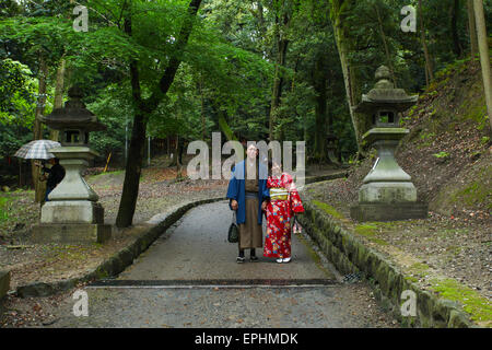 Geisha et partenaire au Sanctuaire Fushimi Inari gardens à Kyoto. Banque D'Images