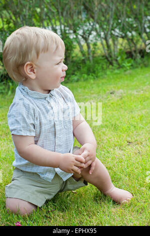 Baby Boy sitting on Green grass Banque D'Images