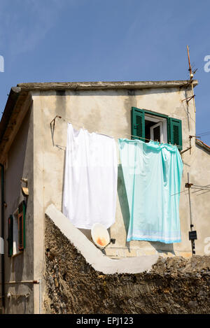 Vue sur la vieille façade à fort contraste entre étendre le linge traditionnel au soleil et une parabole, Portovenere, Italie Banque D'Images