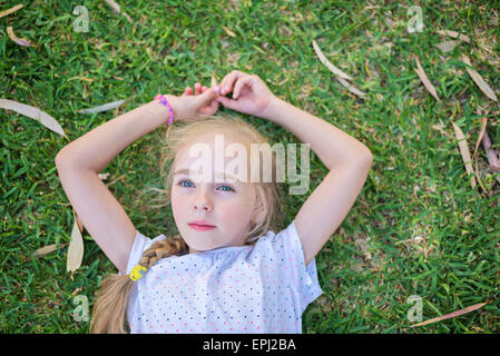 Portrait petite fille jeter sur l'herbe Banque D'Images