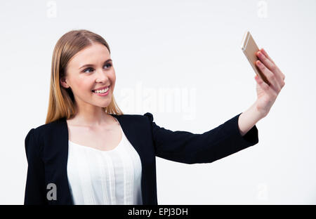 Happy young businesswoman making photo selfies sur smartphone Blackberry sur fond gris Banque D'Images