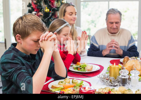 Famille élargie disant grâce avant le dîner de Noël Banque D'Images