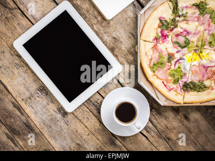 Pause café l'arrière-plan. Maquette de travail avec tablette numérique et tasse de café avec la pizza à la case sur le vieux fond de bois. Haut Banque D'Images