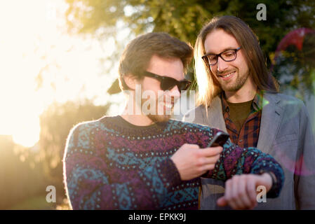 Deux hipsters avec smartwatch et smartphone Banque D'Images