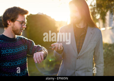 Deux hipsters avec smartwatch et smartphone Banque D'Images