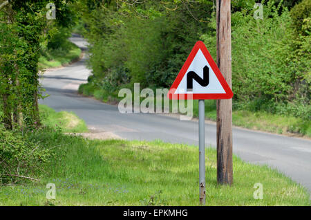 "Double Bend' attention signe de route sur une étroite route de campagne à Norfolk, en Angleterre. Banque D'Images