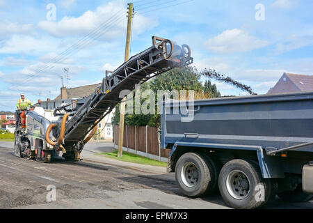Entretien route travaux benne basculante chargement de camion avec usure de surface de tarmac enlevé par le conducteur de machine de planage pour resurfaçage et réparations Essex Angleterre UK Banque D'Images